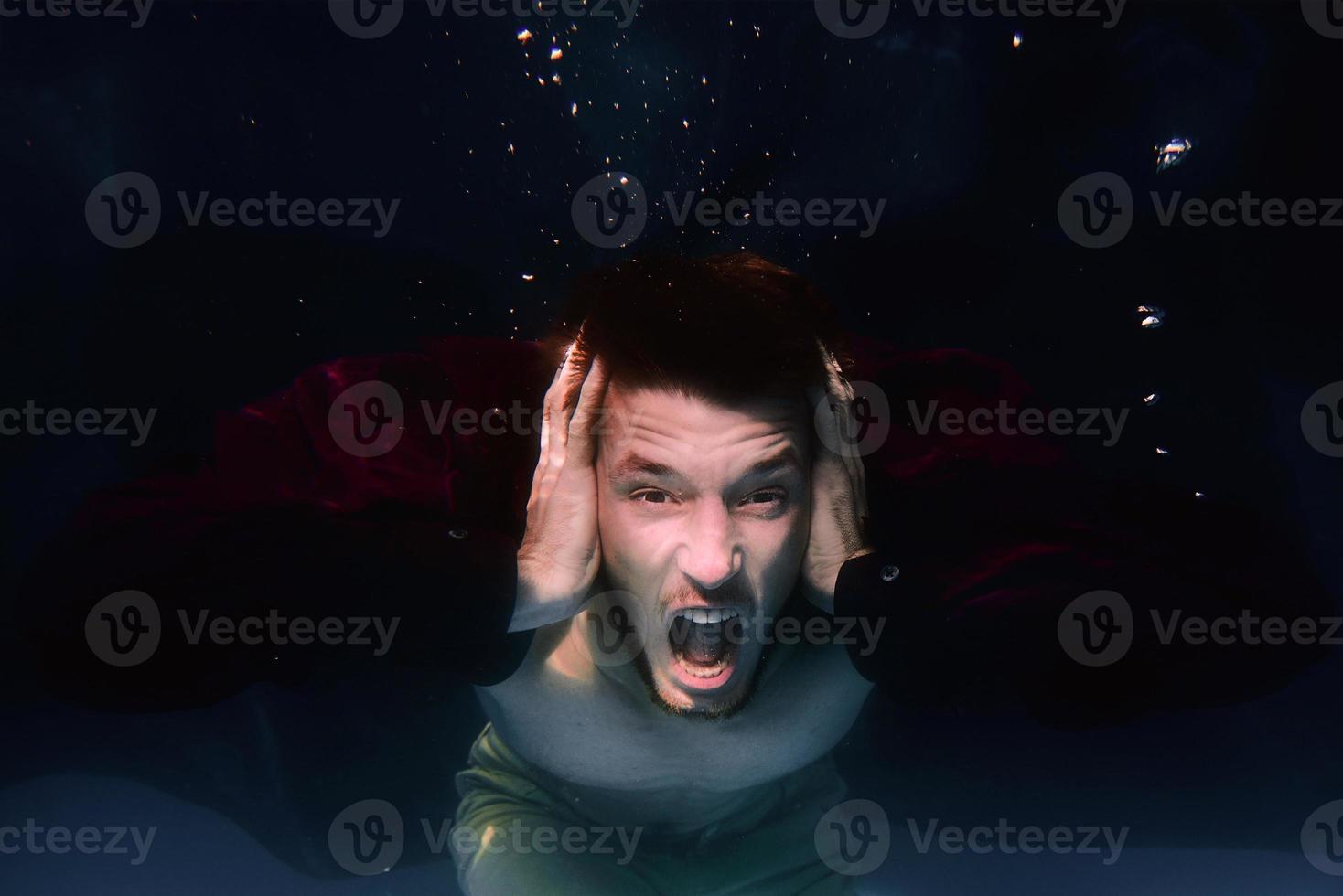 une photo sous-marine d'un homme criant dans une piscine sur fond noir