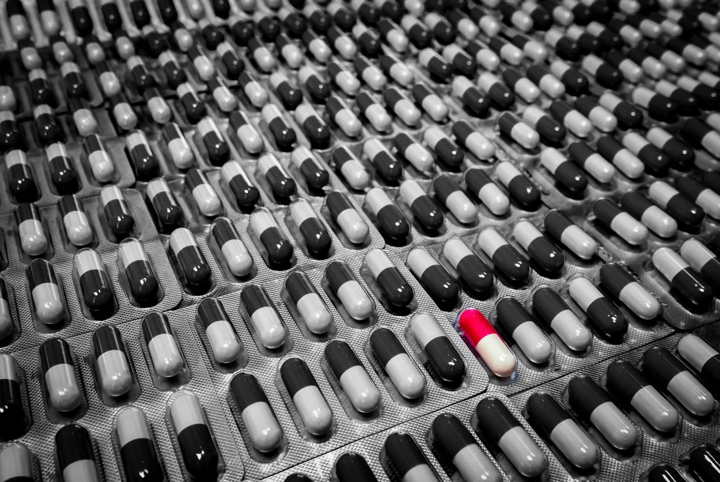 capsule rouge et blanche en capsule monochrome pilule sous blister. capsule exceptionnelle dans la pilule de la foule. sélection des médicaments à l'hôpital. dangers de l'utilisation de médicaments sans consulter le concept d'un médecin ou d'un pharmacien. photo