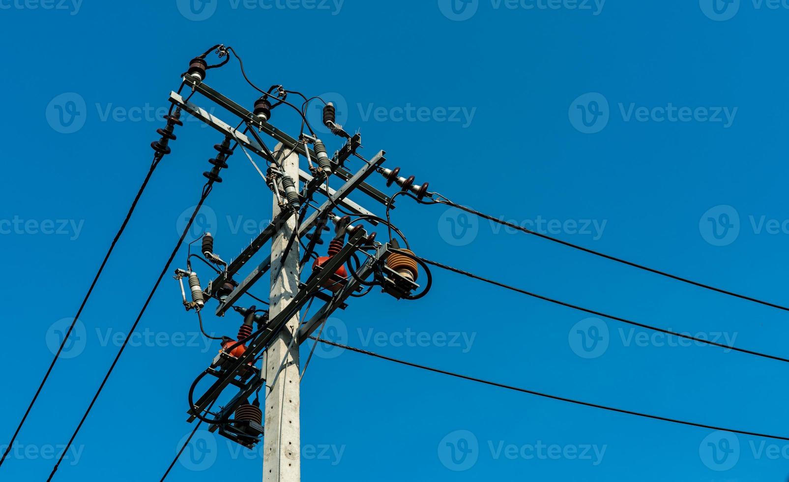 poteau électrique haute tension et lignes de transmission avec ciel bleu clair. pylônes électriques. système d'ingénierie de puissance et d'énergie. danger pylône haute tension. fil de câble sur poteau électrique. industrie de l'énergie. photo