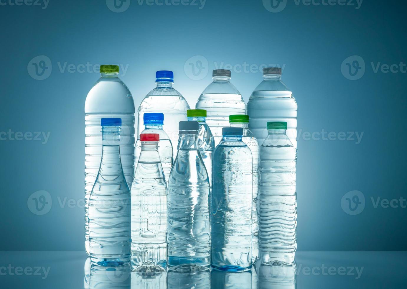 ensemble de bouteille d'eau en plastique transparent avec étiquette vierge. bouteille d'eau claire et de minéraux naturels avec bouchon blanc, vert, rouge et bleu. boisson saine. collection de bouteille en plastique avec liquide plein. photo