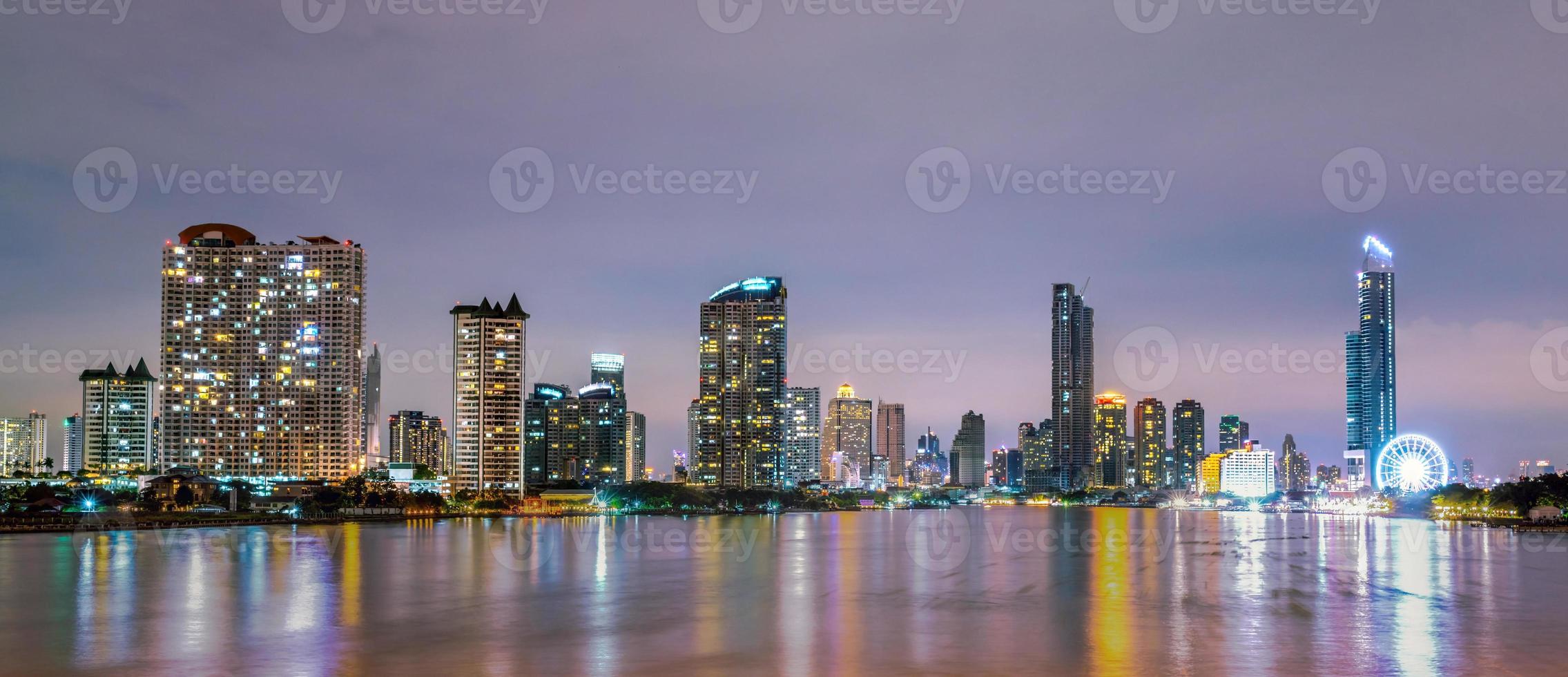 paysage urbain d'un bâtiment moderne près de la rivière dans la nuit. immeuble de bureaux d'architecture moderne. gratte-ciel avec ciel du soir. image de ton noir et blanc. photographie de nuit du bâtiment riverain. photo