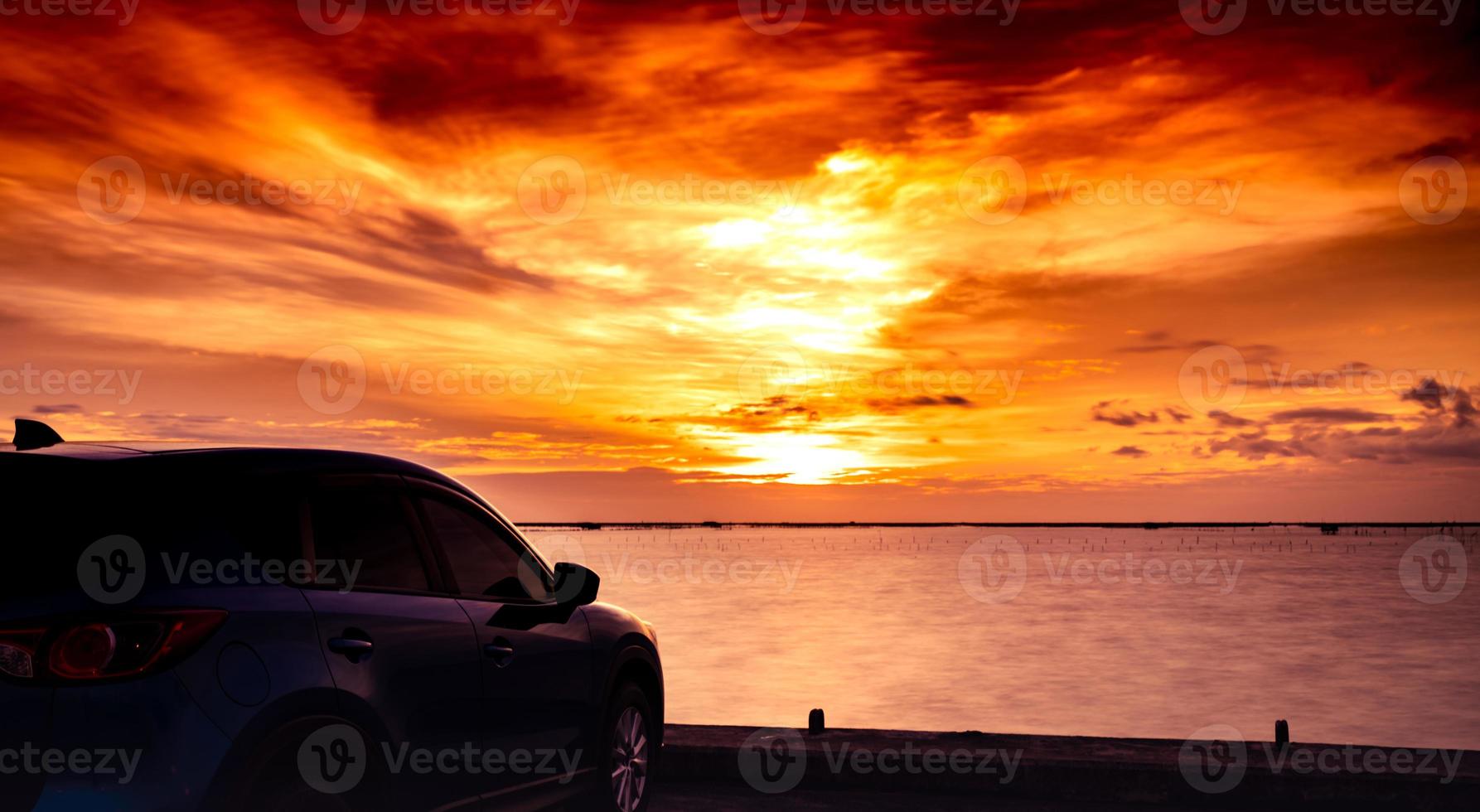 voiture suv compacte bleue au design sport et luxe garée sur une route en béton au bord de la mer au coucher du soleil. technologie et affaires de voitures électriques. automobile hybride et automobile. voyage sur la route tropicale. automobile photo