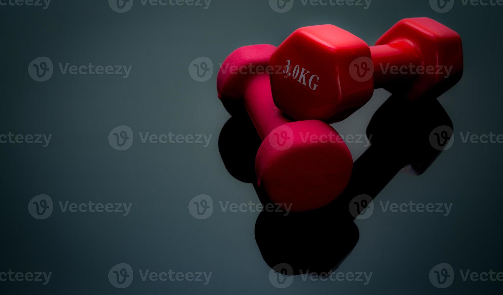 haltères rouges et roses foncés isolés sur fond noir. 2, 3 kg d'haltères. équipement de musculation. accessoires d'entraînement de musculation. équipement pour faire de l'exercice en salle de sport ou à la maison. équipement sportif. photo