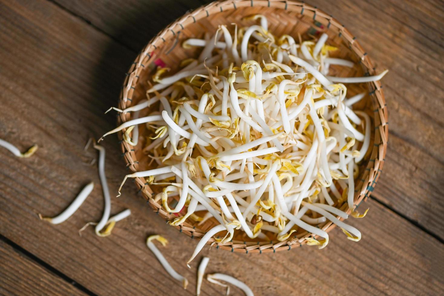 germes de soja sur fond de table de panier en bois dans la cuisine, germes de soja bio blancs crus ou germes de haricot mungo pour la nourriture végétalienne photo