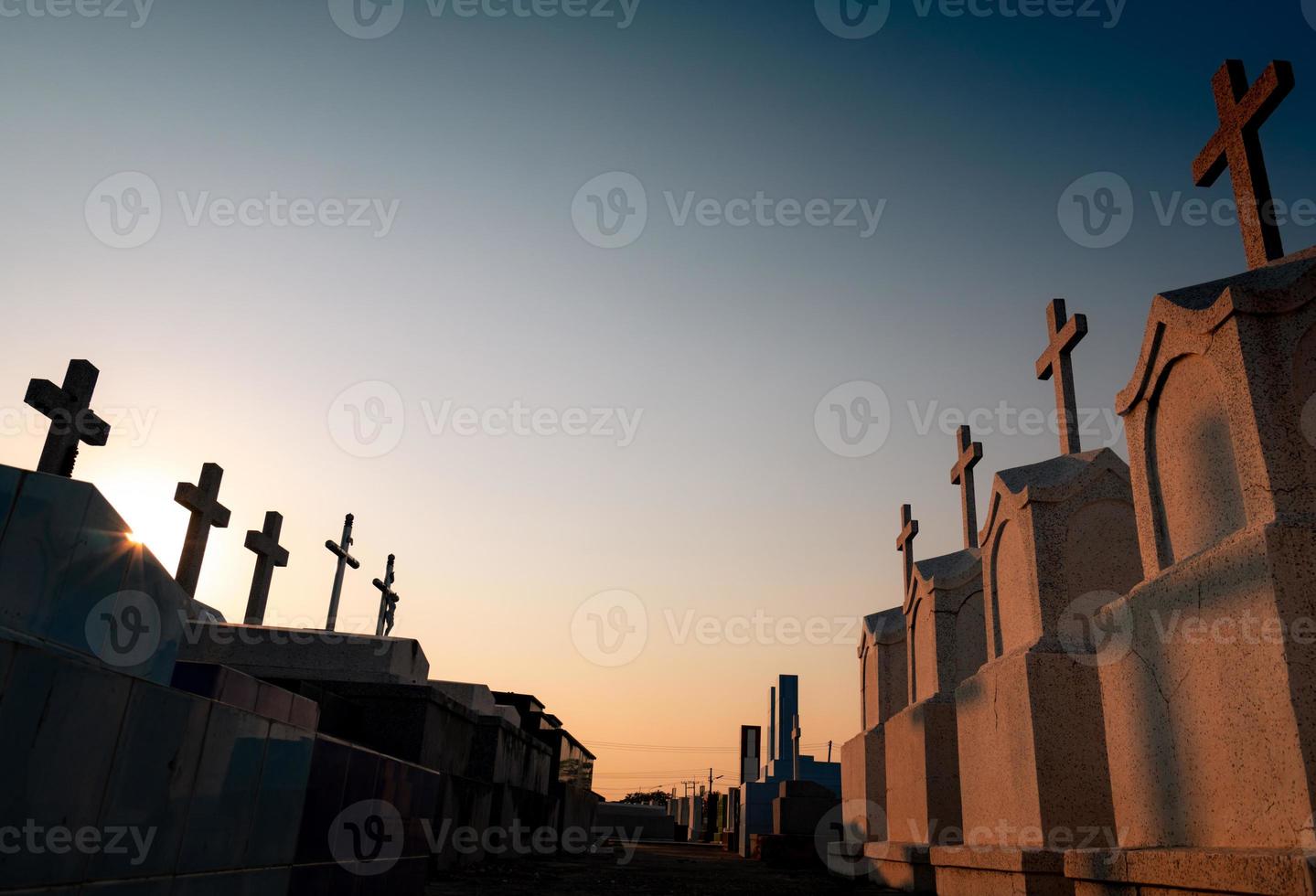 cimetière ou cimetière le soir avec ciel coucher de soleil. cimetière de pierres tombales et de pierres tombales. reposez en paix. conception funéraire. fond de tristesse, de lamentation et de mort. passerelle entre le cimetière. photo