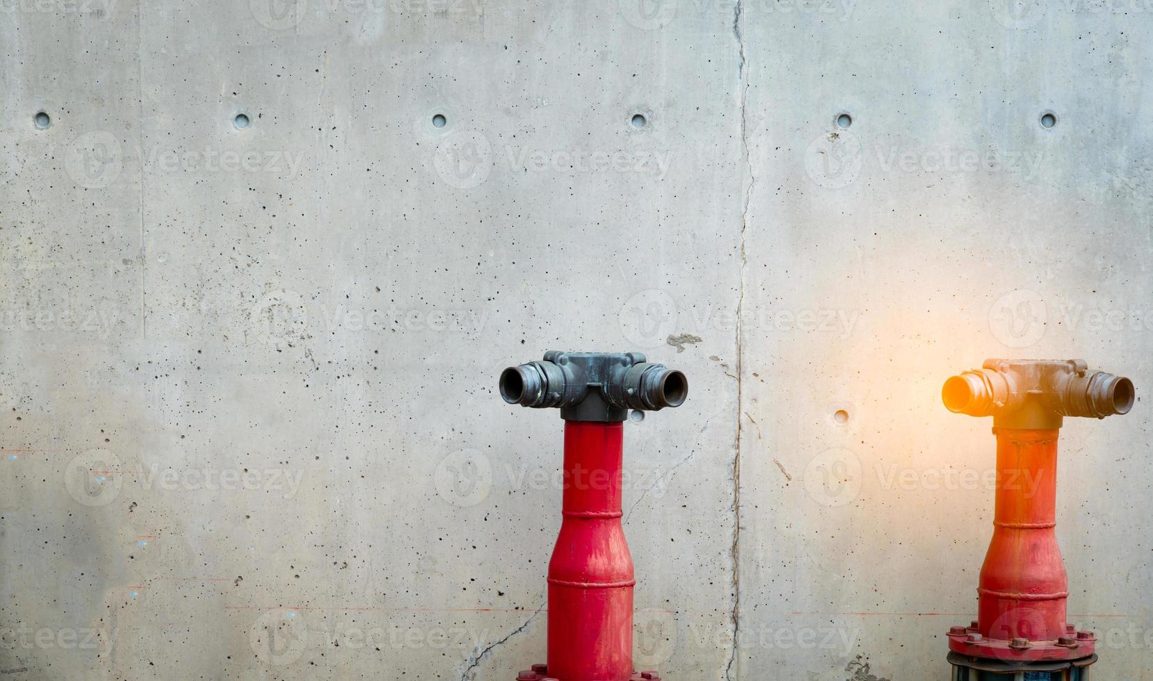 pompe de sécurité incendie sur le sol en ciment du bâtiment en béton. système déluge du système de lutte contre les incendies. plomberie protection incendie. pompe à incendie rouge devant un mur de béton. pompe de sécurité incendie haute pression. photo