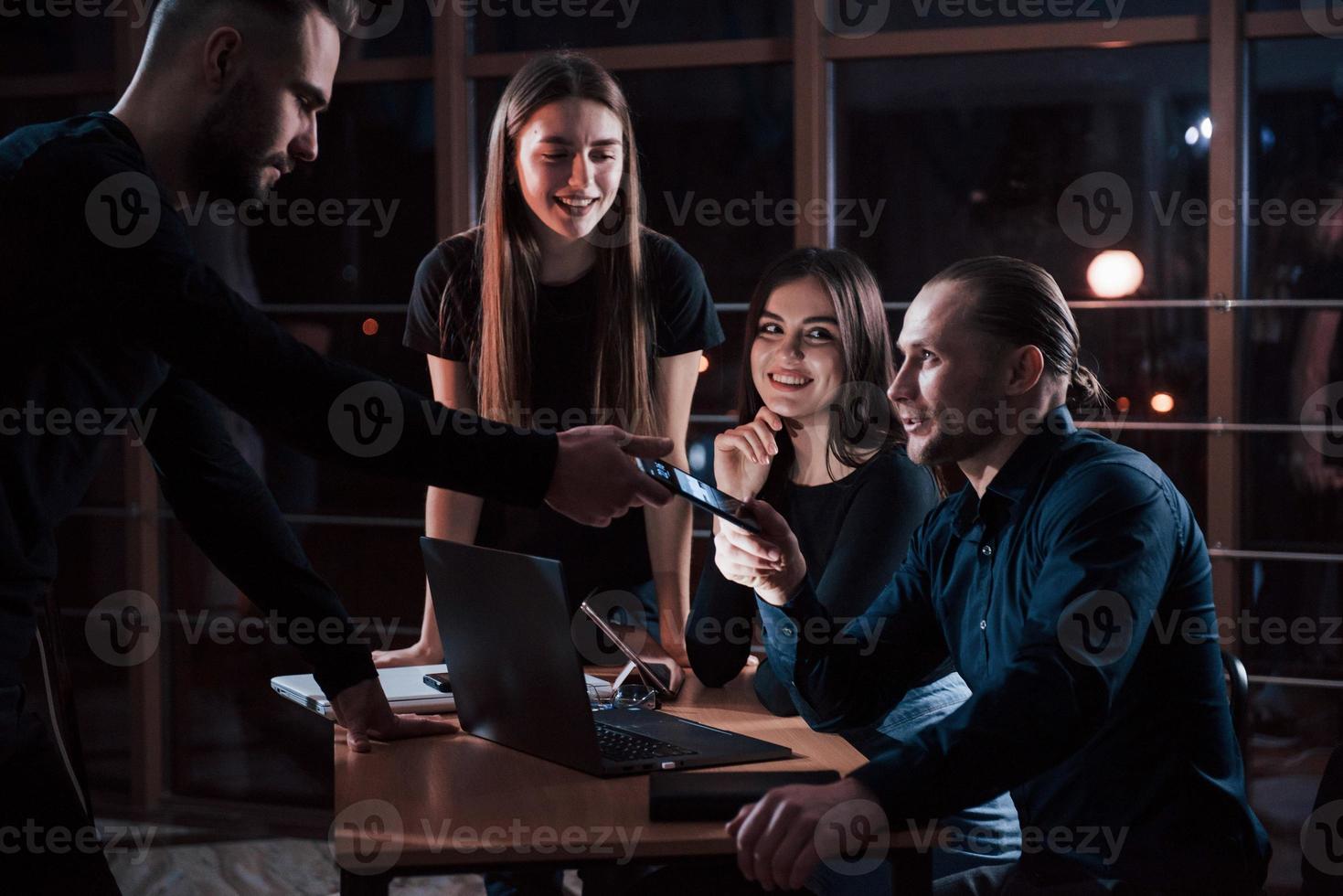 Vous avez un appel. une équipe de jeunes hommes d'affaires travaille sur leur projet la nuit au bureau photo