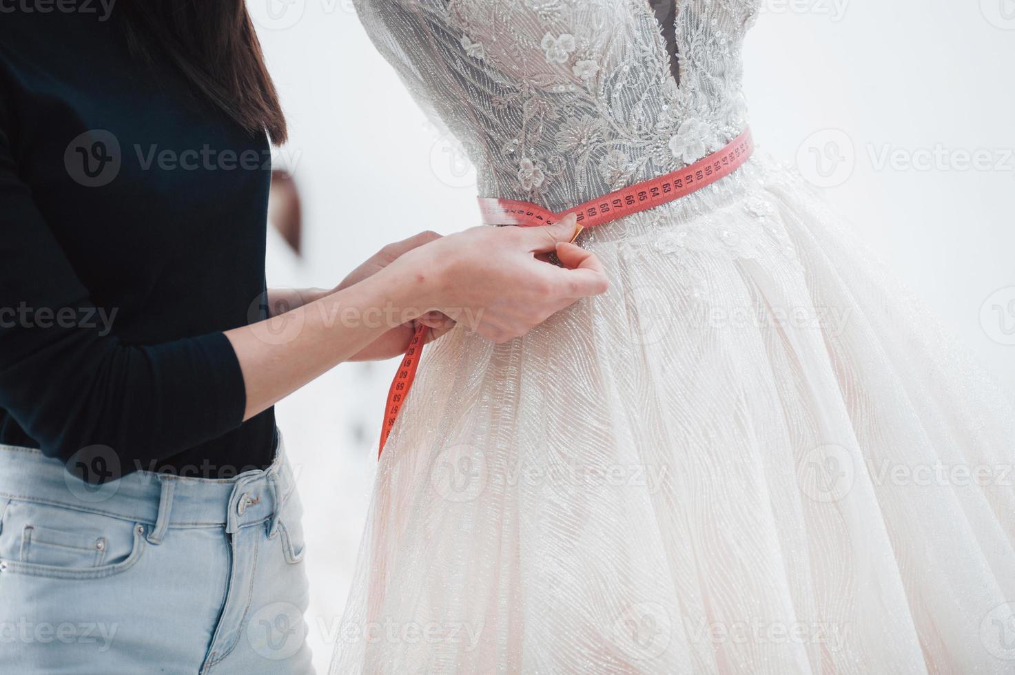 travail quotidien ordinaire. le processus d'essayage de la robe dans l'atelier de vêtements fabriqués à la main photo