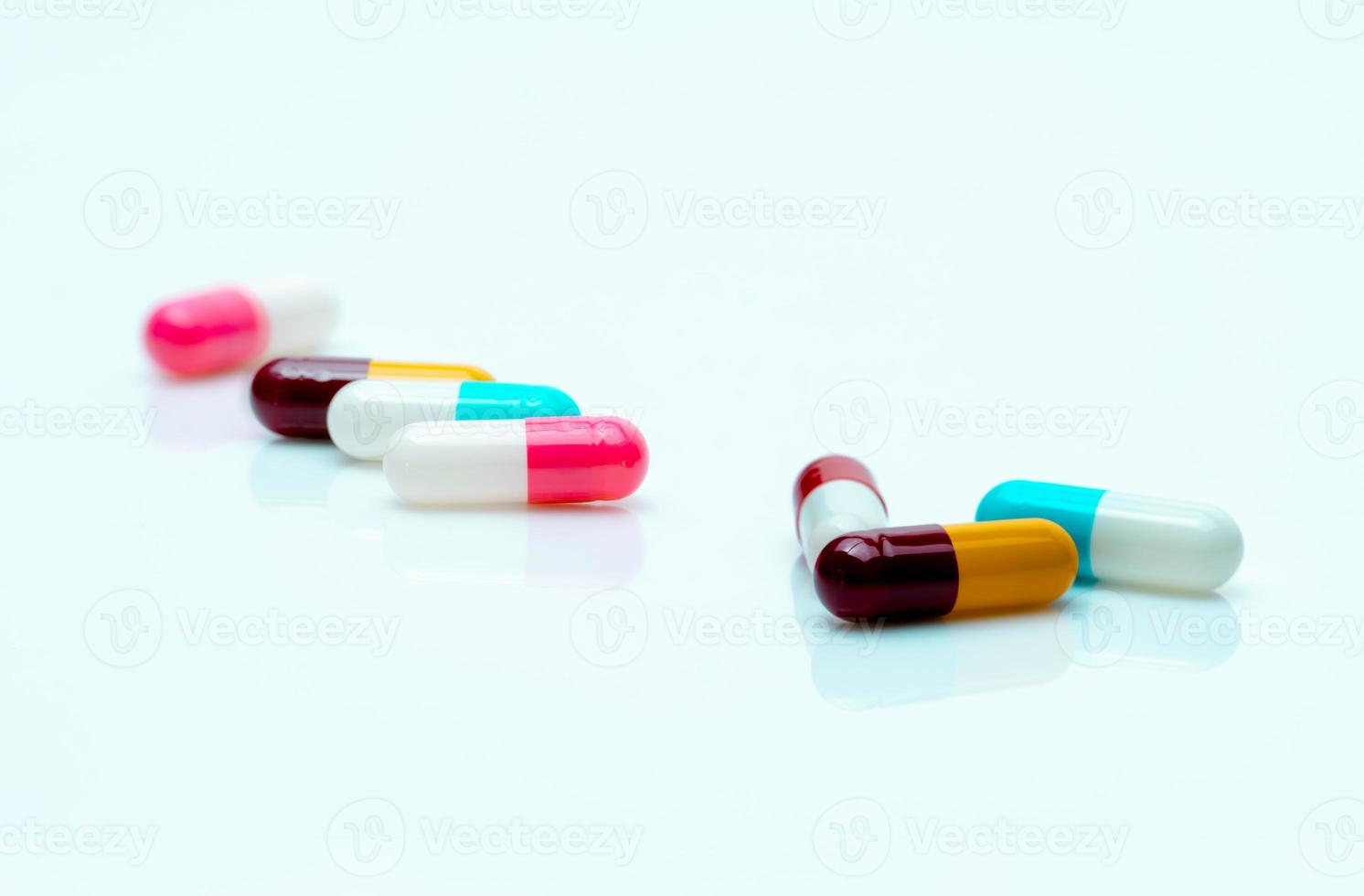 pilules multicolores sur fond blanc. pilules de capsule antibiotique. médicaments d'ordonnance. industrie pharmaceutique. notion de polymédication. fabrication de capsules. la santé et la médecine. médicaments antimicrobiens. photo