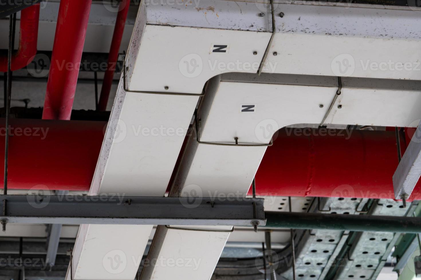 système de conduits électriques. pipeline métallique installé sur le mur de plafond du bâtiment. chemin de câble électrique au sous-sol du centre commercial ou de l'usine. tuyaux d'alimentation en eau rouges. suppression des incendies. photo