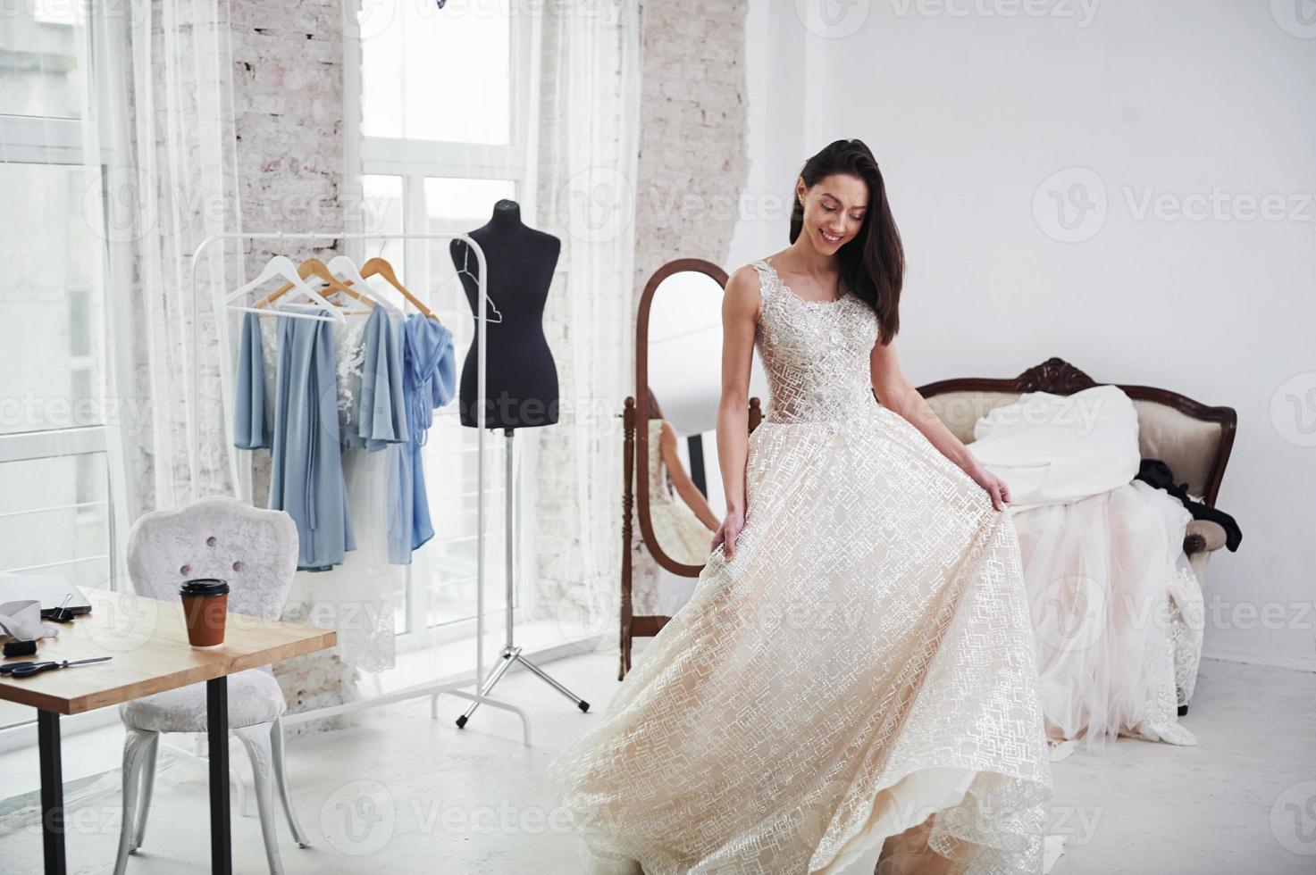 c'est tellement long. le processus d'essayage de la robe dans l'atelier de vêtements fabriqués à la main photo