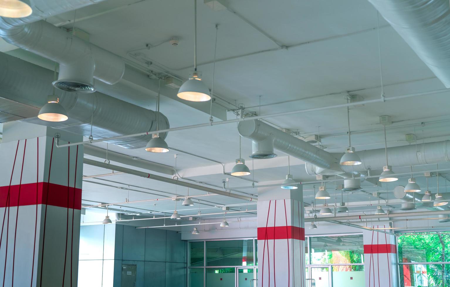 conduit d'air, tuyau de climatiseur, système de gicleurs d'incendie. circulation d'air et système de ventilation. intérieur du bâtiment. plafonnier lumière avec lumière ouverte. Architecture d'intérieur. bâtiment de mur de verre. photo