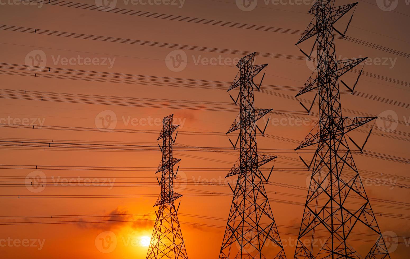 pylône électrique haute tension et fil électrique avec ciel coucher de soleil. poteaux électriques. concept d'usine de soutien électrique et énergétique. tour de réseau haute tension avec câble métallique. beau ciel coucher de soleil rouge-orange. photo