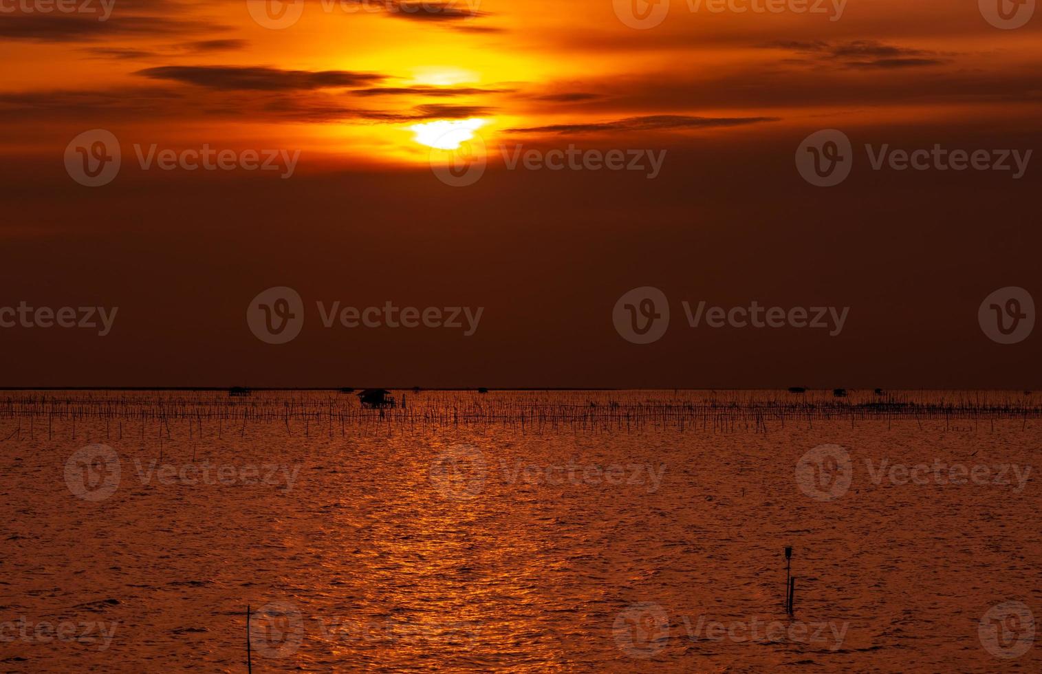 beau coucher de soleil sur la mer. ciel et nuages sombres et dorés au coucher du soleil. fond de nature pour un concept tranquille et paisible. coucher de soleil à chonburi, thaïlande. photo d'art du ciel au crépuscule. l'élevage en mer.