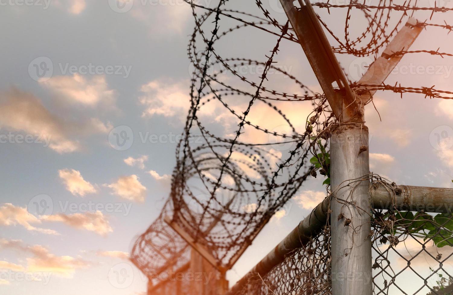 barrière de sécurité de la prison. clôture de sécurité en fil de fer barbelé. clôture de prison en barbelés. frontière barrière. mur de sécurité frontalier. prison pour arrêter des criminels ou des terroristes. zone privée. notion de zone militaire. photo