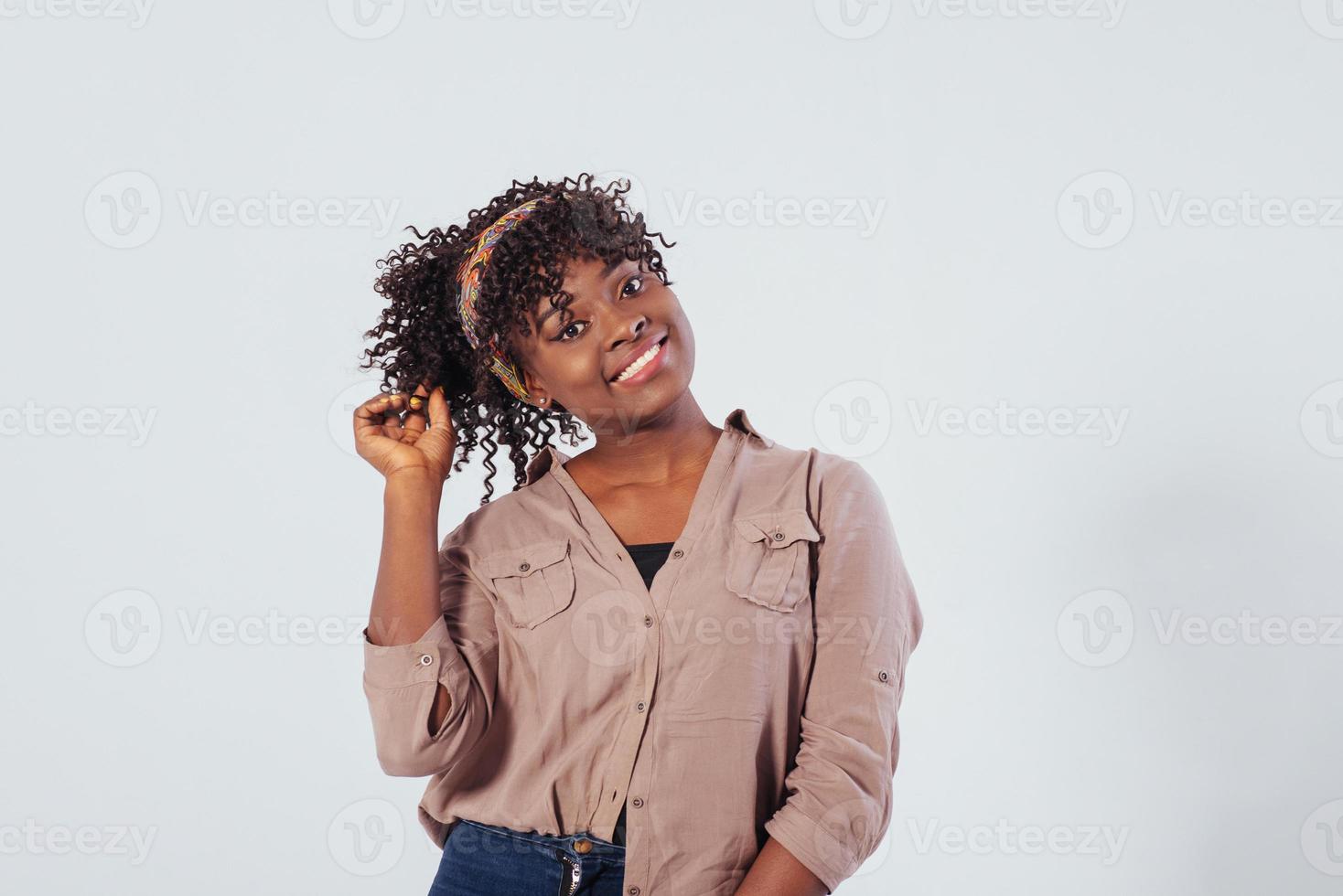 une jolie femme. belle fille afro-américaine aux cheveux bouclés dans le studio avec un fond blanc photo
