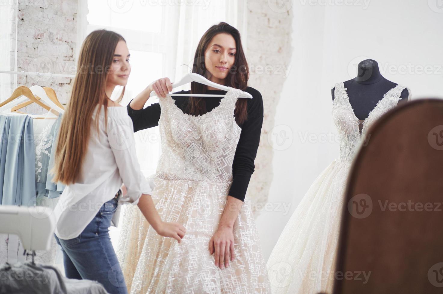 s'assiéra parfaitement sur vous. le processus d'essayage de la robe dans l'atelier de vêtements fabriqués à la main photo