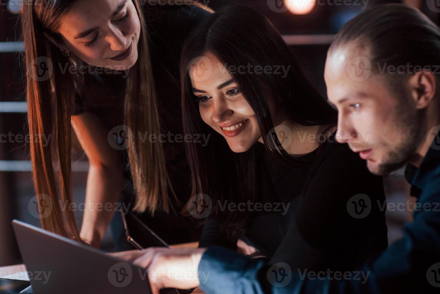 fille heureuse. une équipe de jeunes hommes d'affaires travaille sur leur projet la nuit au bureau photo