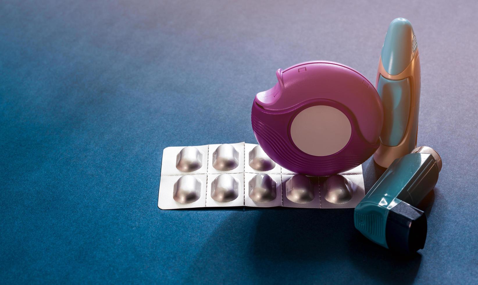 ensemble d'inhalateurs pour l'asthme, d'accuhaler et de pilules anti-allergiques pour le traitement de l'asthme. contrôleur d'asthme, équipement de secours sur table bleue avec espace de copie. bronchodilatateur et stéroïdes pour l'asthme sévère. photo