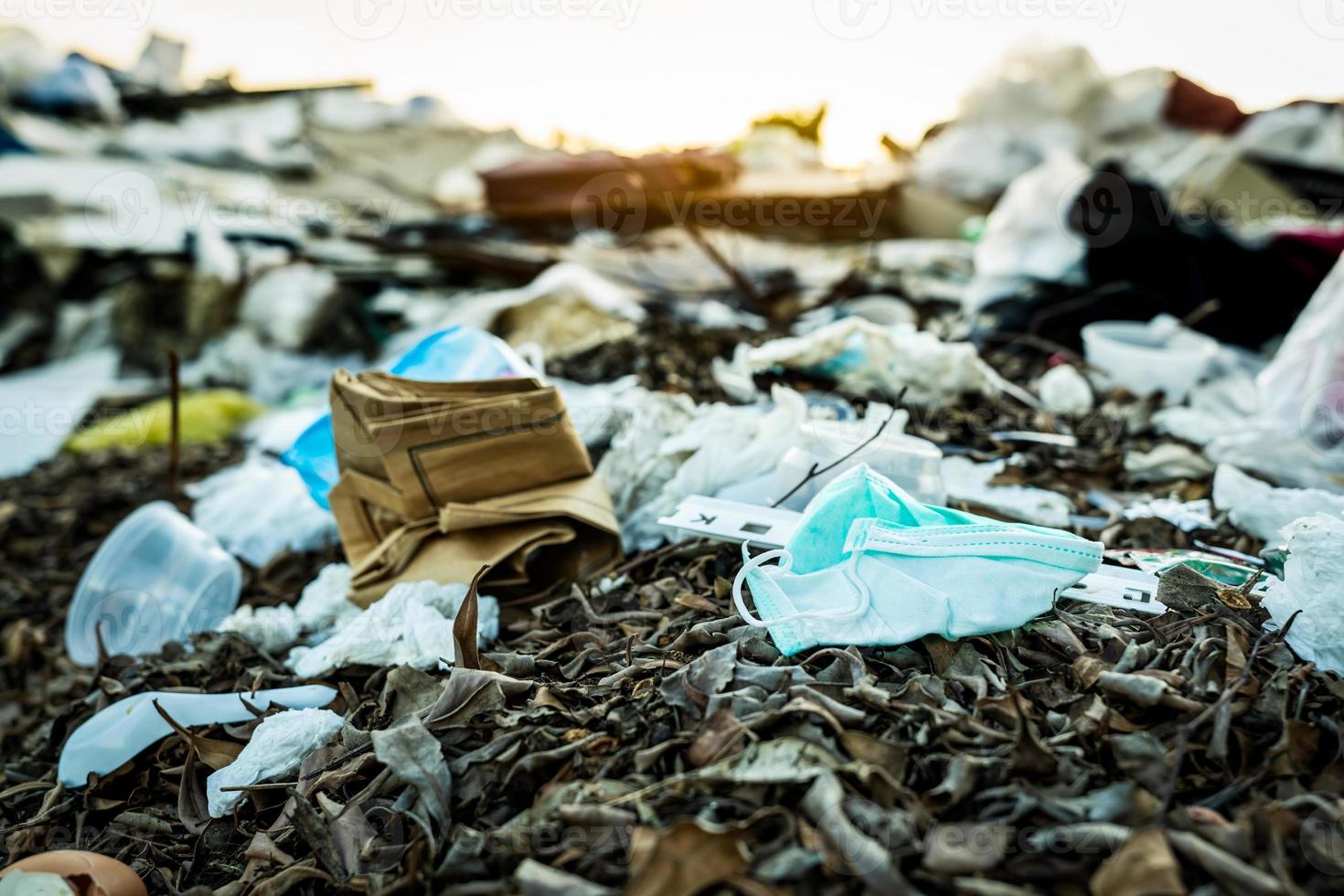 jeter le masque facial utilisé dans les ordures ménagères. élimination des déchets médicaux avec gestion insalubre. déchets contaminés dans la communauté. masque facial à contour d'oreille jetable déchets de déchets sur le sol. impact du coronavirus photo