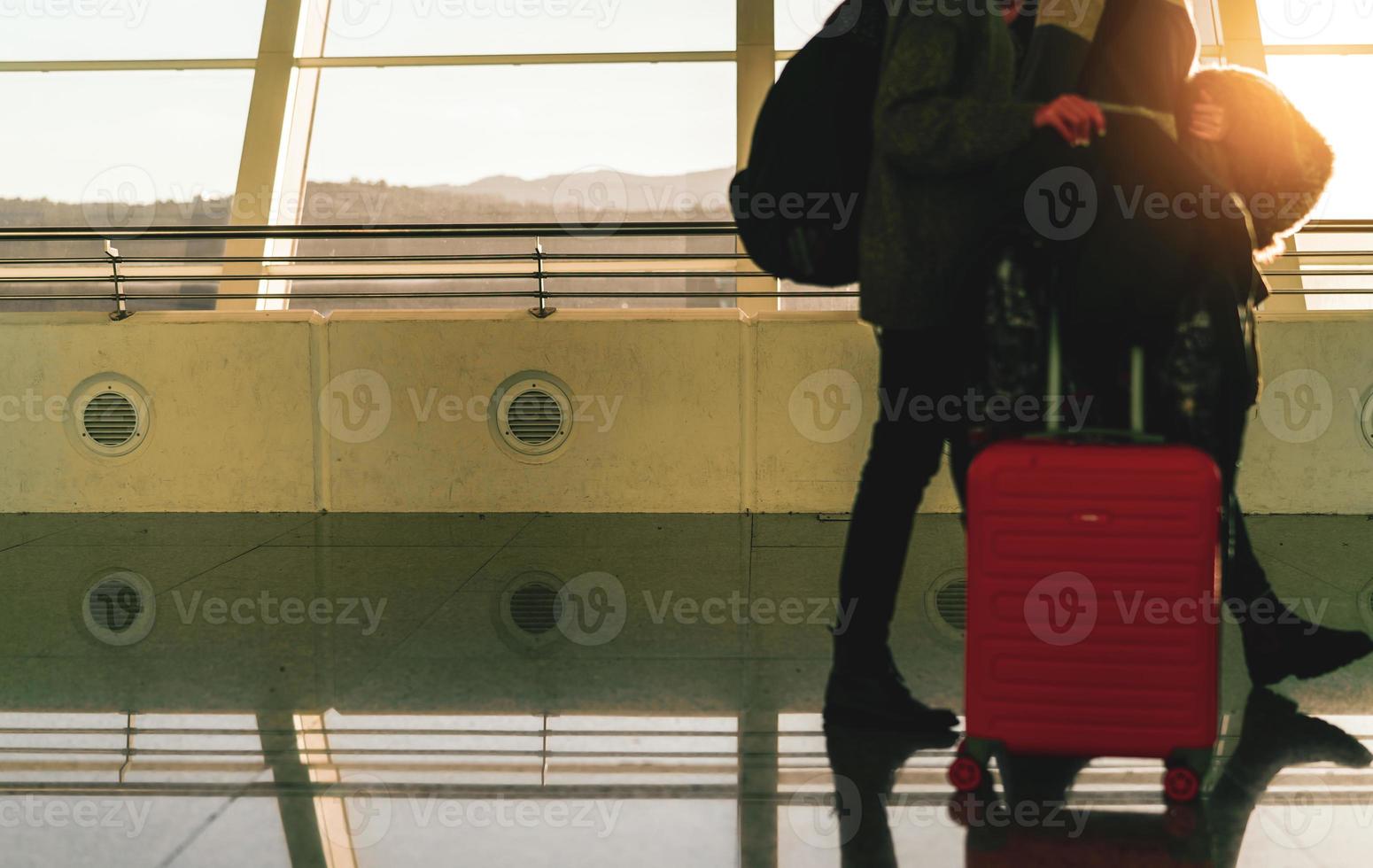 touriste flou avec bagages marchant dans l'aéroport international. passager de la compagnie aérienne avec bagages le matin avec le lever du soleil. voyage de vacances à l'étranger et concept de transfert de vol. voyage en couple heureux. photo