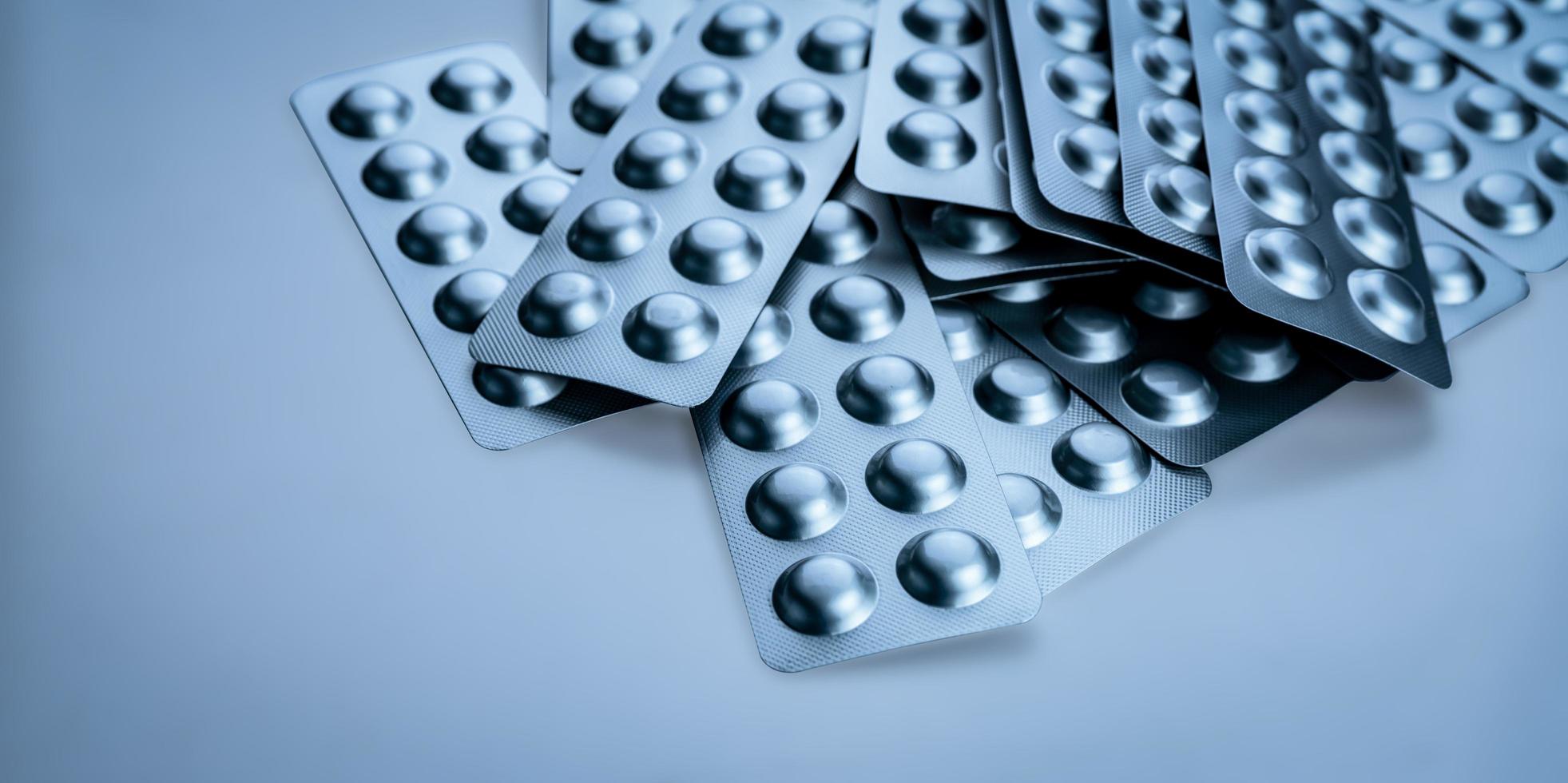 tas de comprimés comprimé sous blister pour protéger les médicaments de la lumière. blister en feuille d'aluminium argenté. industrie pharmaceutique. produits pharmaceutiques. rappel de médicament et concept de retrait du marché photo