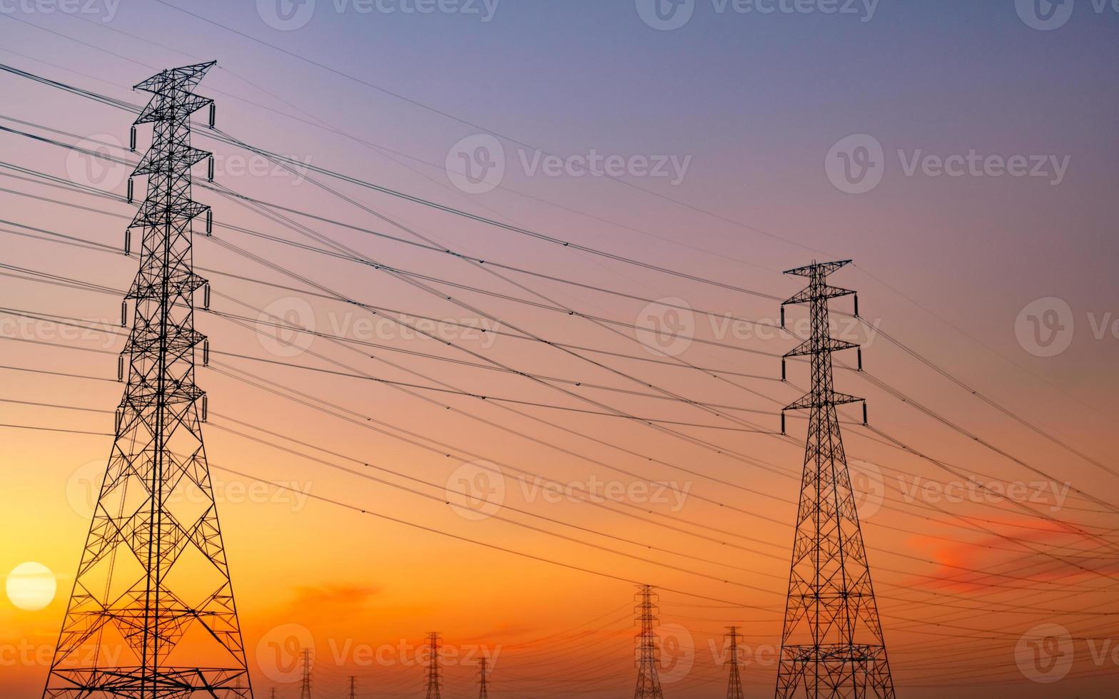 silhouette pylône électrique haute tension et fil électrique avec ciel coucher de soleil violet et rouge. poteaux électriques au coucher du soleil. concept de puissance et d'énergie. tour de réseau haute tension avec câble métallique. pylônes en acier. photo
