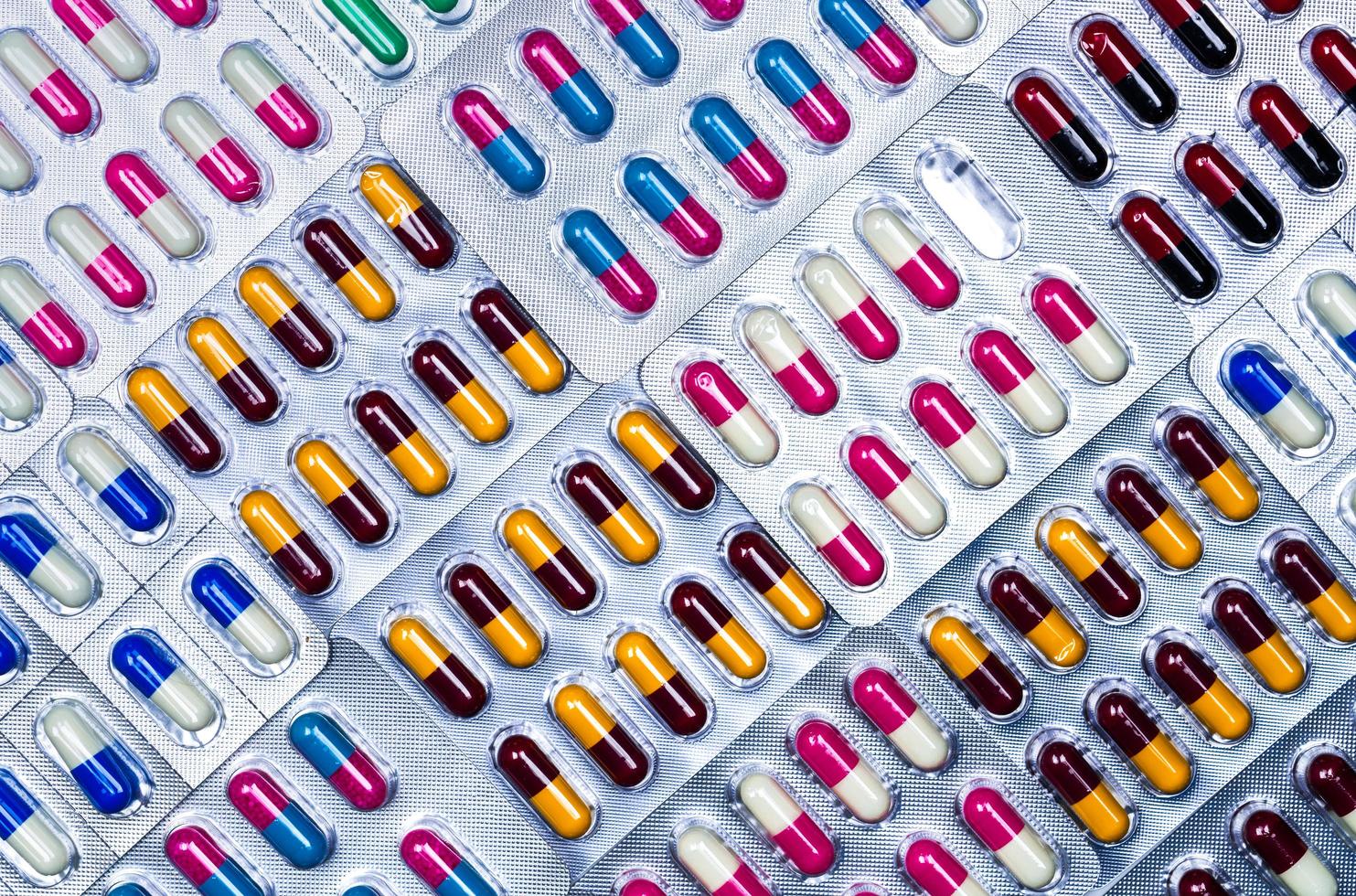 cadre complet de pilules de capsules antimicrobiennes colorées. erreur de contrôle de la qualité dans la fabrication pharmaceutique. blister manque une capsule de pilule antibiotique. résistance aux médicaments. notion défectueuse. photo