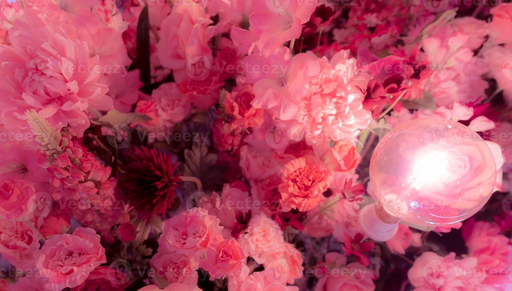 mise au point sélective sur une fleur en plastique rose et rouge avec lampe. fausses fleurs. bouquet de fleur en plastique pour la décoration lors d'un mariage ou de la saint valentin. fleur pour l'amour et fond abstrait romantique. photo