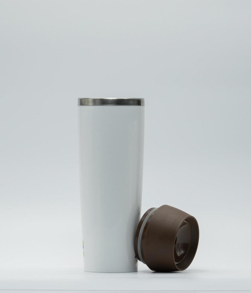 bouteille thermos moderne argentée et blanche avec couvercle ouvert isolé sur fond blanc. tasse à café ou à thé en acier inoxydable. gobelet avec bouchon marron. bouteille de boisson. tasse thermos en aluminium. verre de voyage. photo