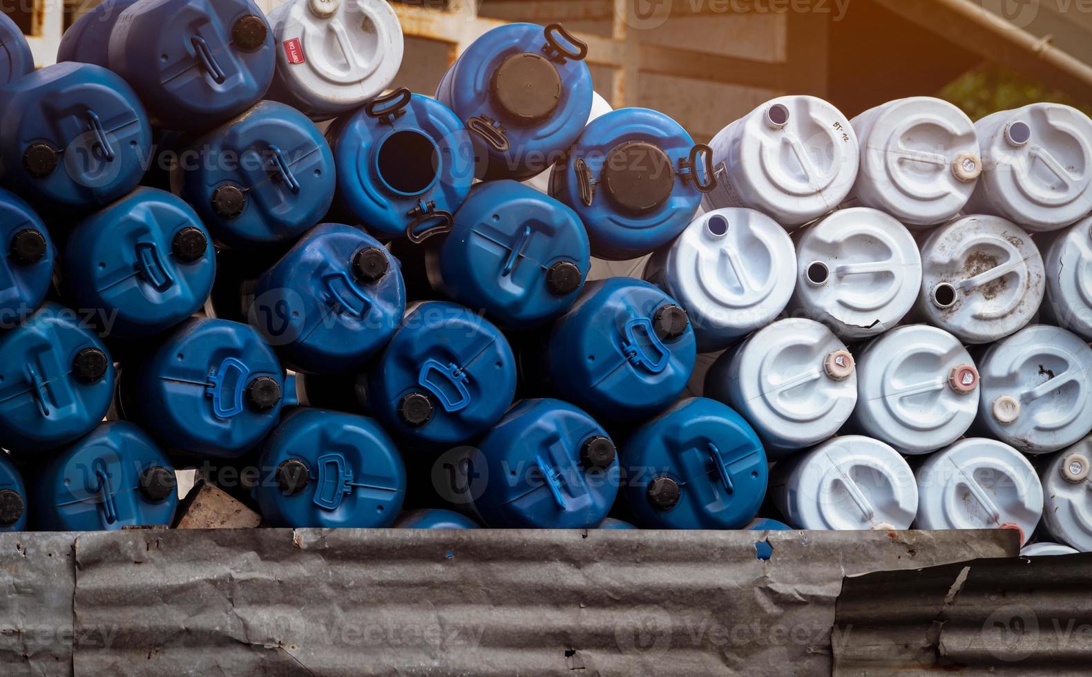 mise au point sélective sur les vieux barils chimiques vides. baril de pétrole bleu et blanc. réservoir d'huile en plastique. entrepôt de déchets toxiques. baril de produits chimiques dangereux. fût en plastique de déchets industriels. bidon vide et étiquette de passage qc. photo