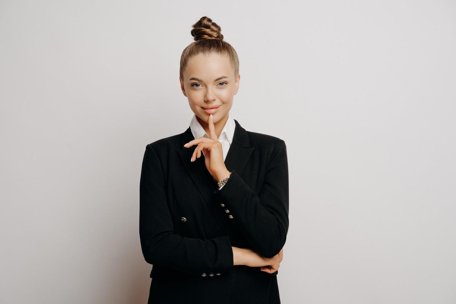 femme propriétaire d'entreprise en costume sombre avec un geste confiant photo