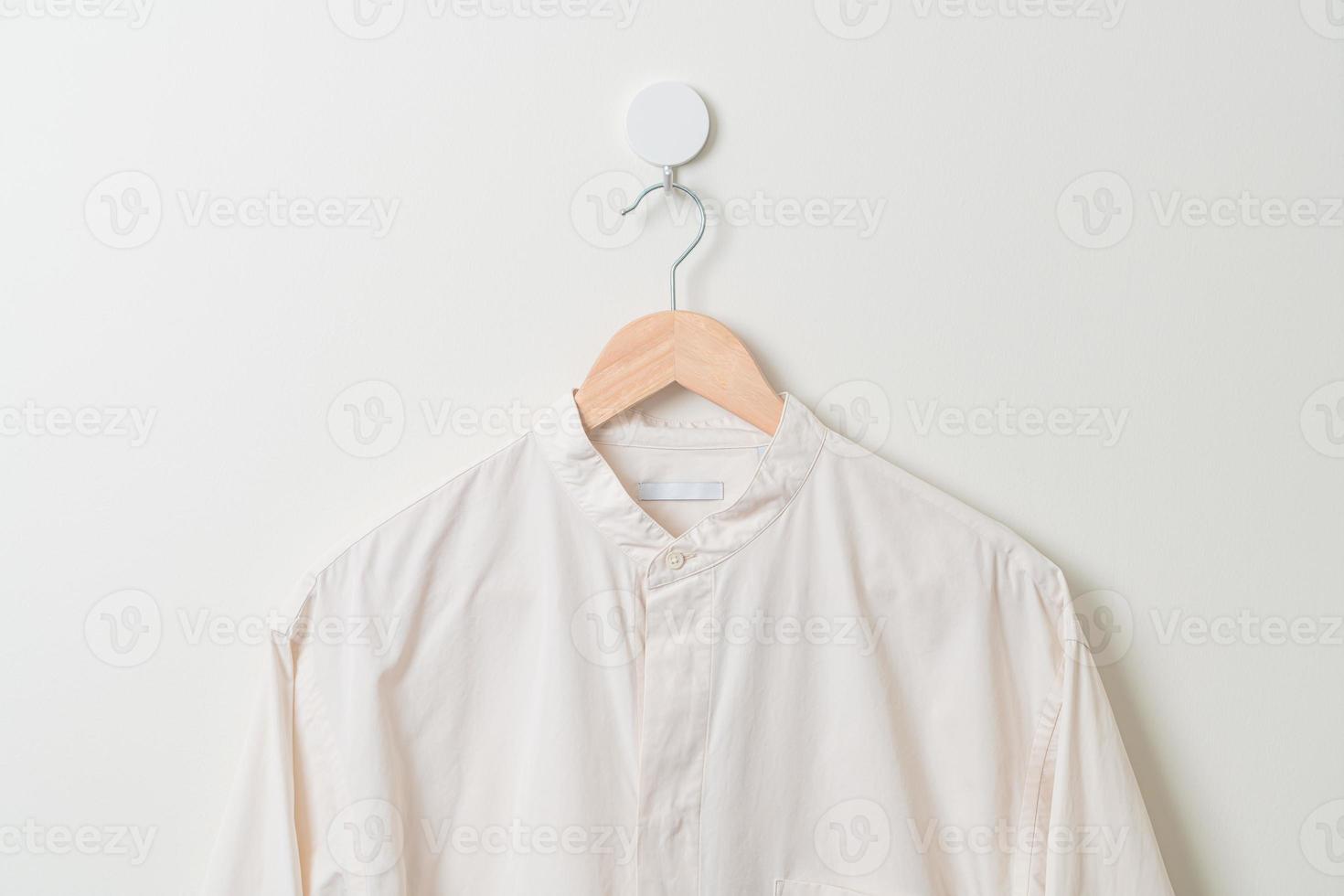 chemise suspendue avec cintre en bois au mur photo