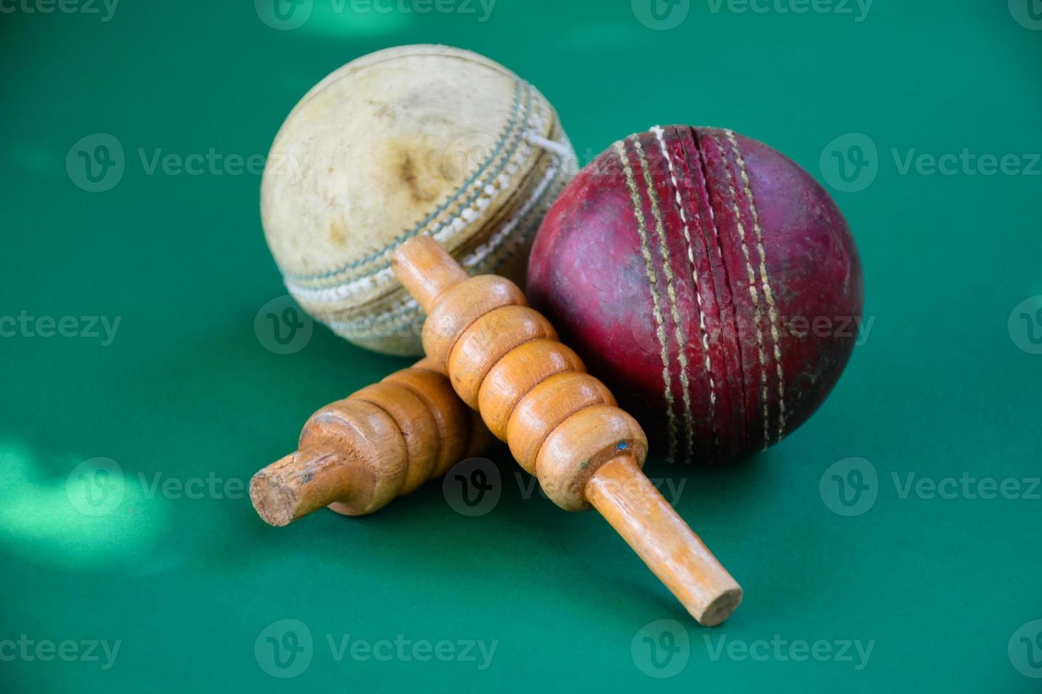 gros plan vieux équipements de sport de cricket sur sol vert, vieux ballon en cuir et guichets en bois, mise au point douce et sélective, amateurs de sport de cricket traditionnels autour du concept mondial. photo