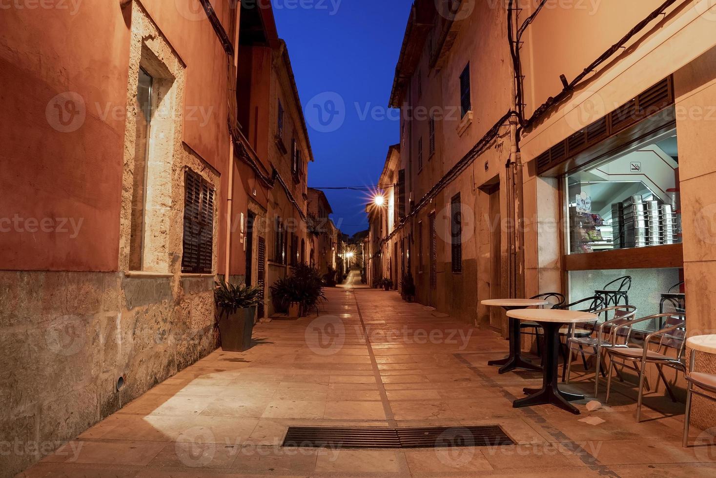 tables et chaises dans une allée illuminée à l'extérieur du restaurant de la ville résidentielle photo