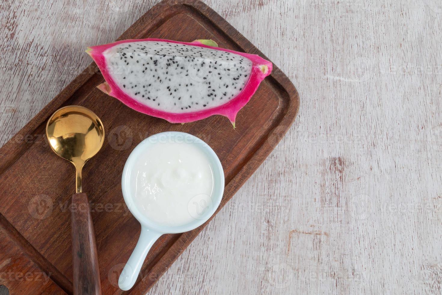 le yaourt d'aliments sains dans un bol a des fruits sur une table en bois blanc. photo