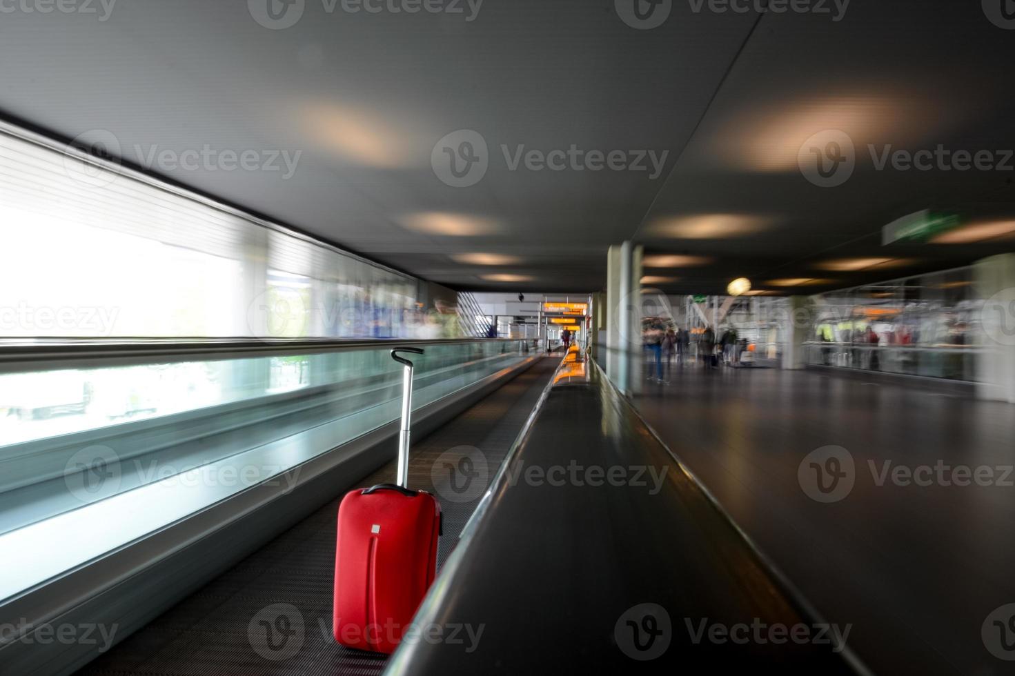 Escalier mécanique en mouvement floue avec chariot rouge à l'aéroport photo