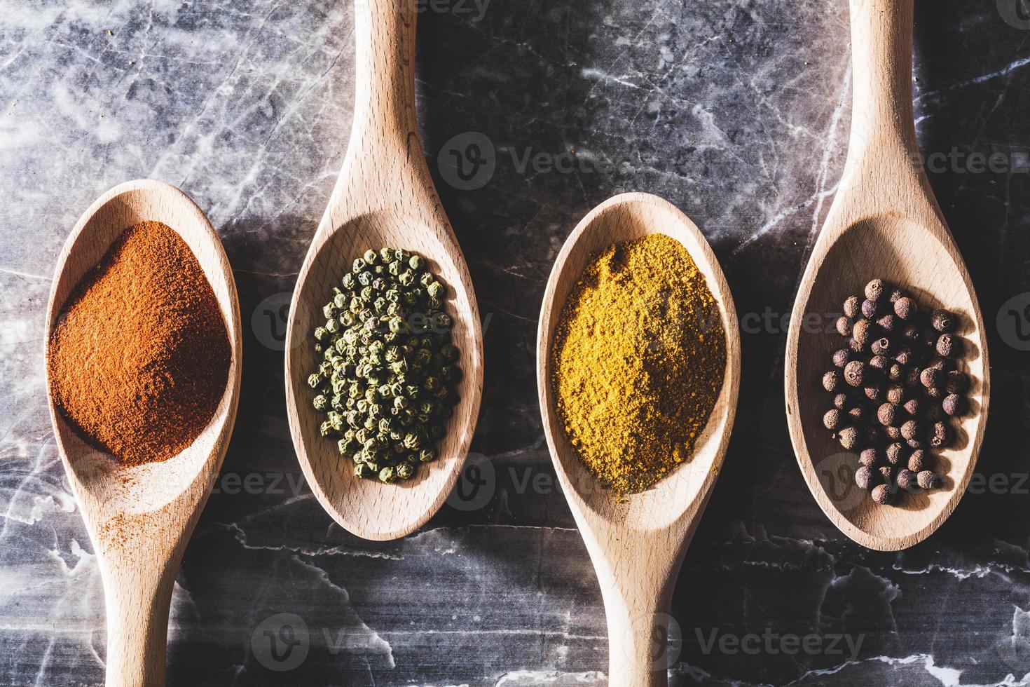 quatre cuillères de cuisine en bois avec différentes épices photo