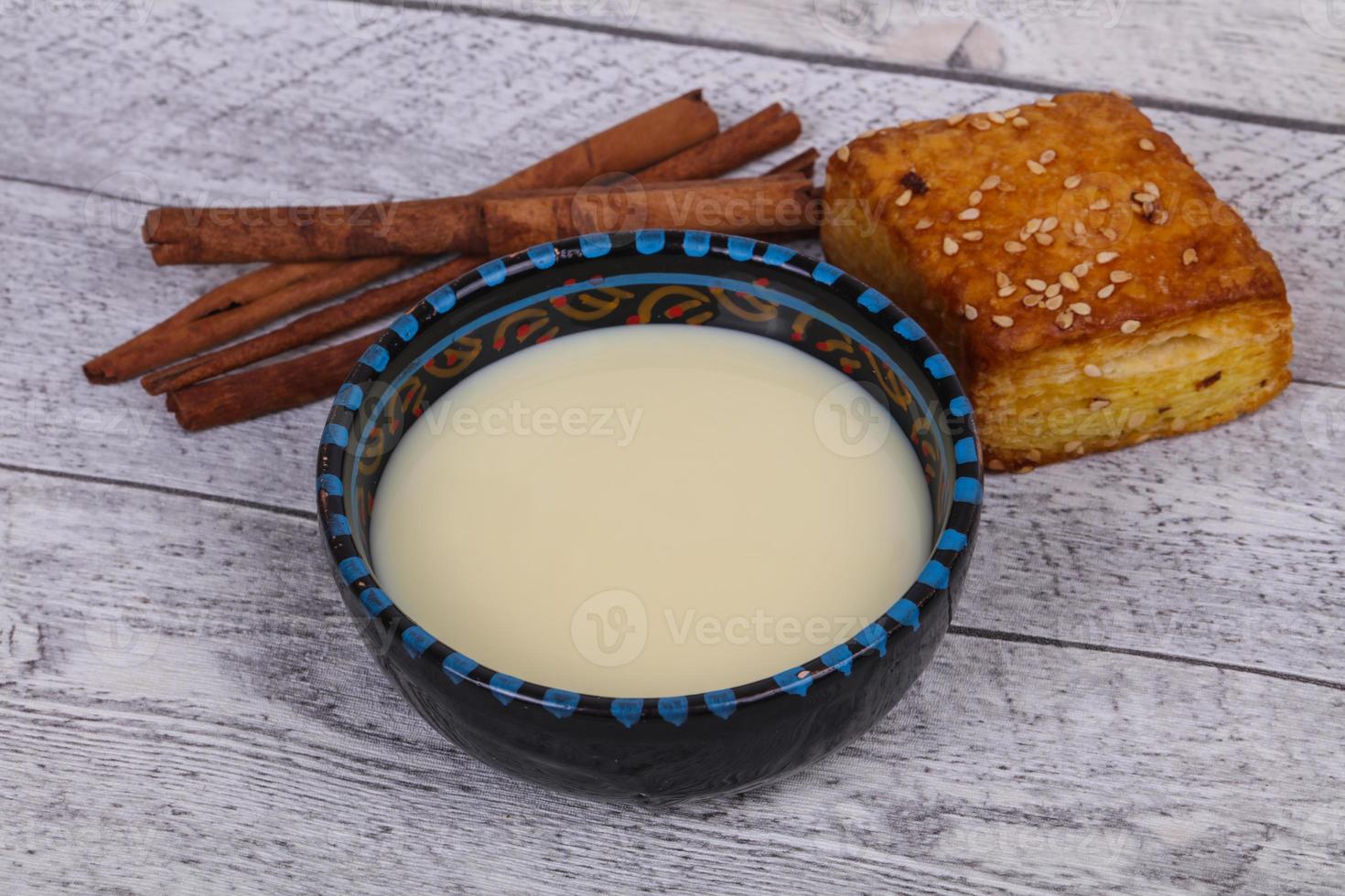 lait concentré dans le bol avec sinnamon et pâtisserie photo