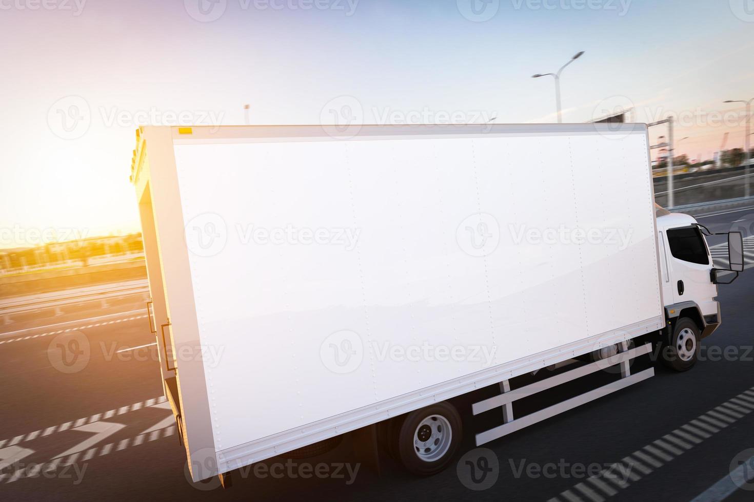 camion de livraison de fret commercial avec remorque blanche vierge conduisant sur l'autoroute. photo