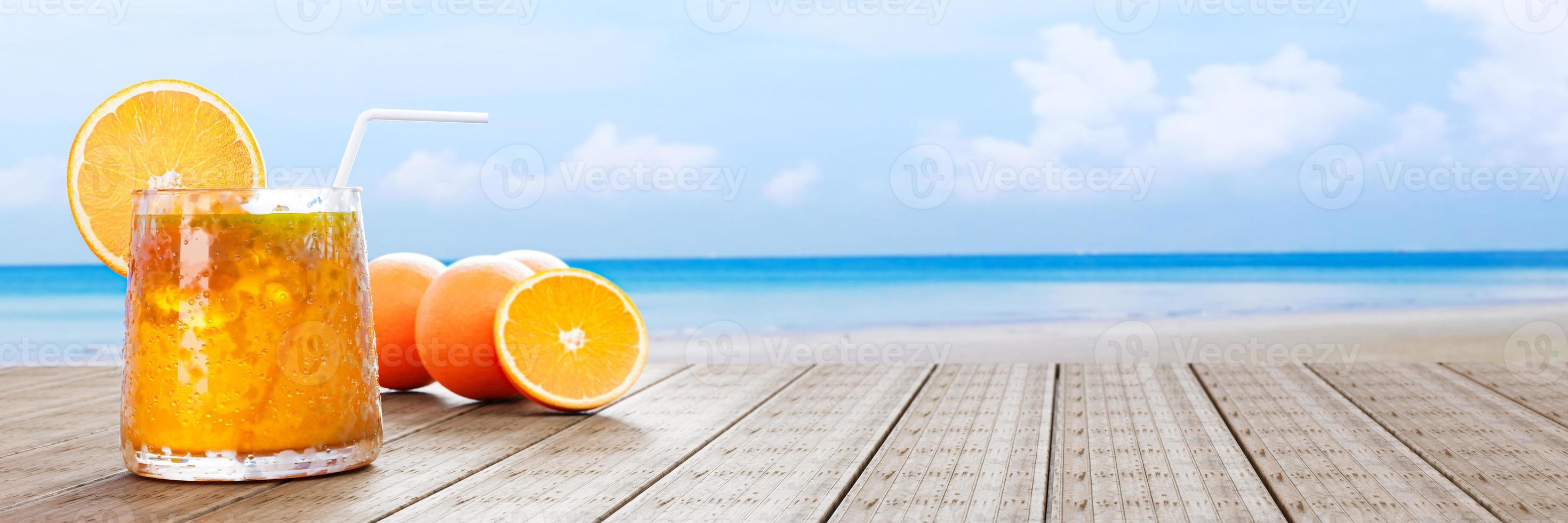 jus d'orange dans un verre transparent avec des glaçons et du jus d'orange à l'embouchure du verre. boissons fraîches posées sur le balcon en bois au bord de la mer en milieu de journée. rendu 3d photo