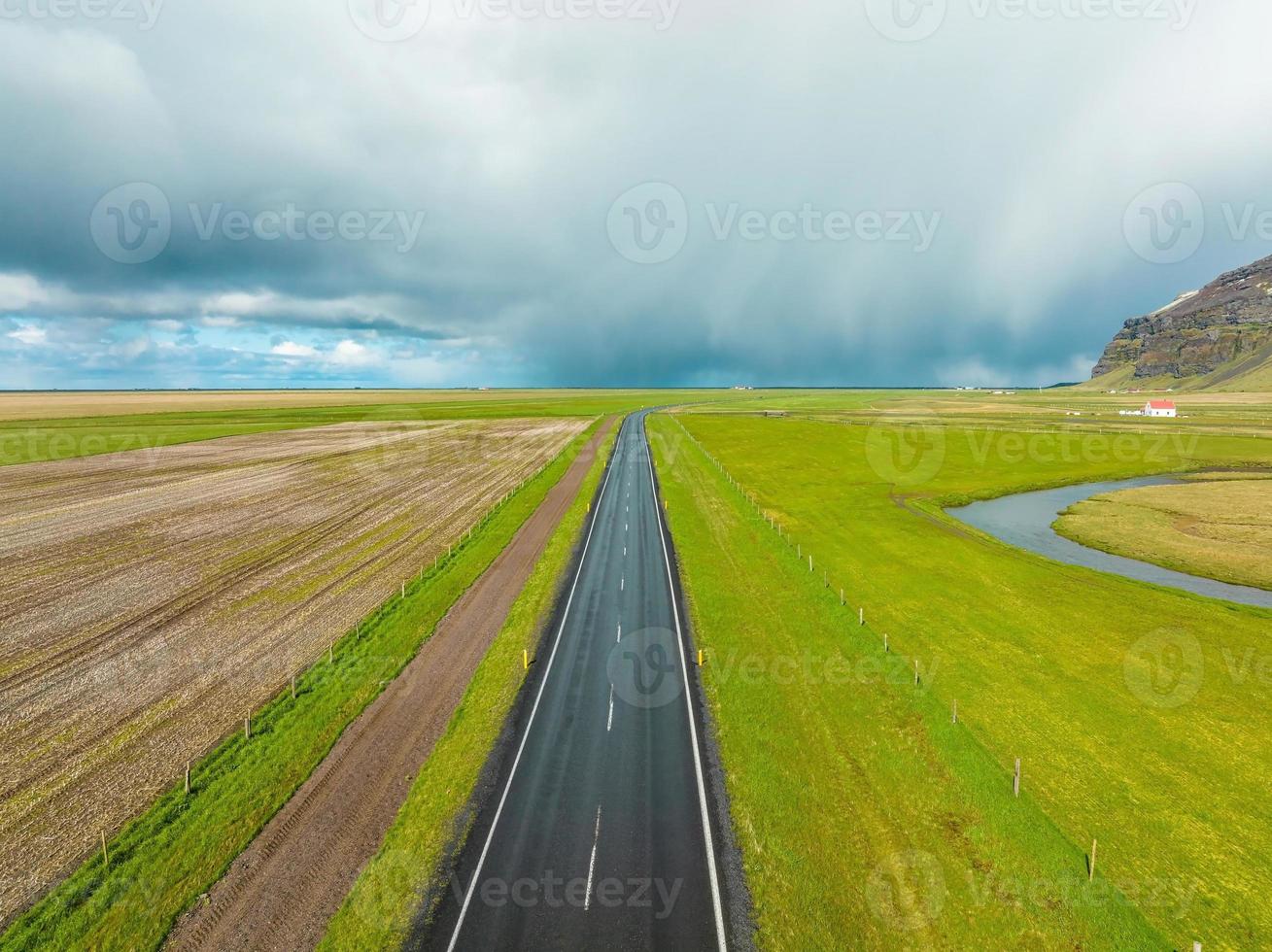 route sans fin dans les montagnes nuageuses et les collines d'islande par temps nuageux ensoleillé. photo