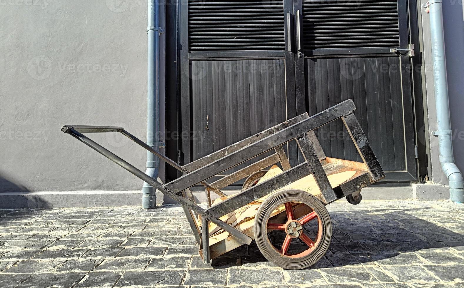 petit vieux chariot de fret noir rouillé. lumière du soleil de midi photo