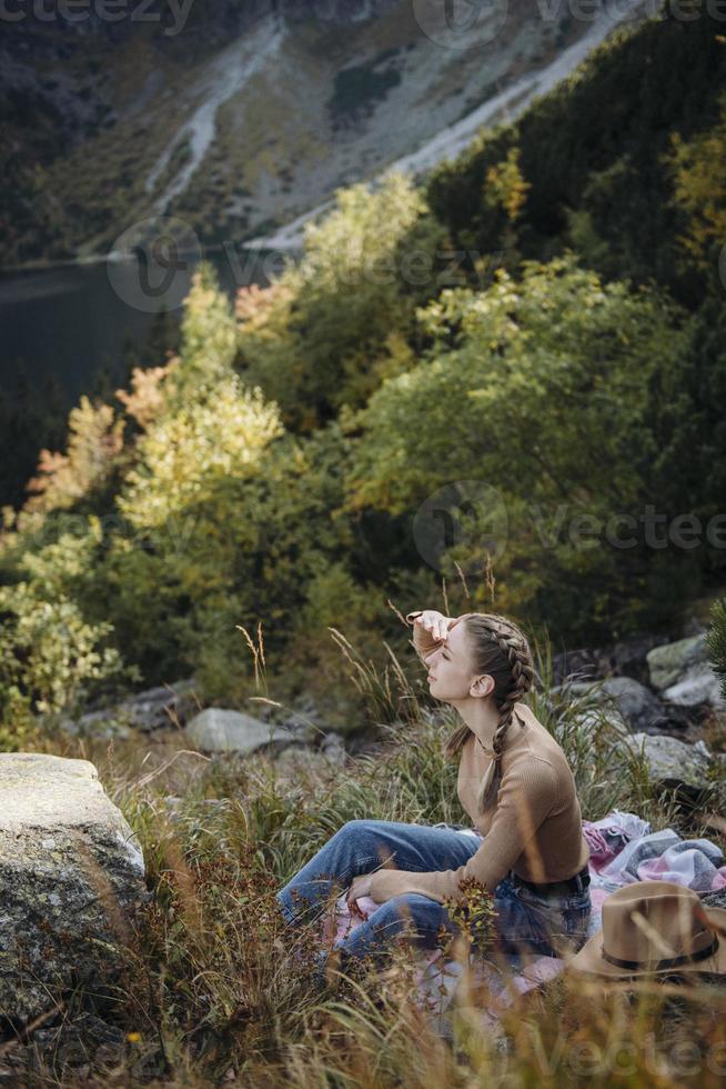 jeune femme en randonnée assise sur un rocher photo