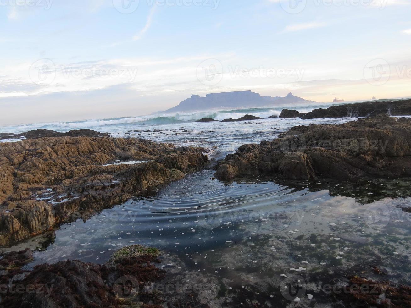 l'eau ondulant à travers les rochers au bord de la mer photo