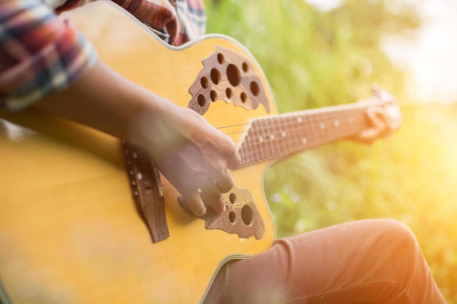 jeune femme hipster jouant de la guitare pour se détendre pendant ses vacances, profiter de l'air naturel et frais. photo