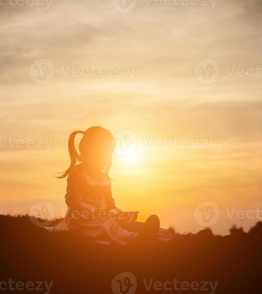 silhouette d'enfant, moments de joie de l'enfant. sur le coucher de soleil nature photo