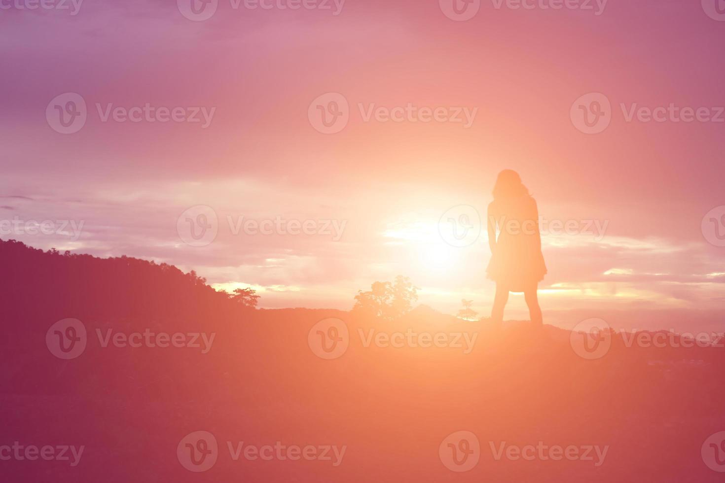 silhouette de femme priant sur fond de ciel magnifique photo