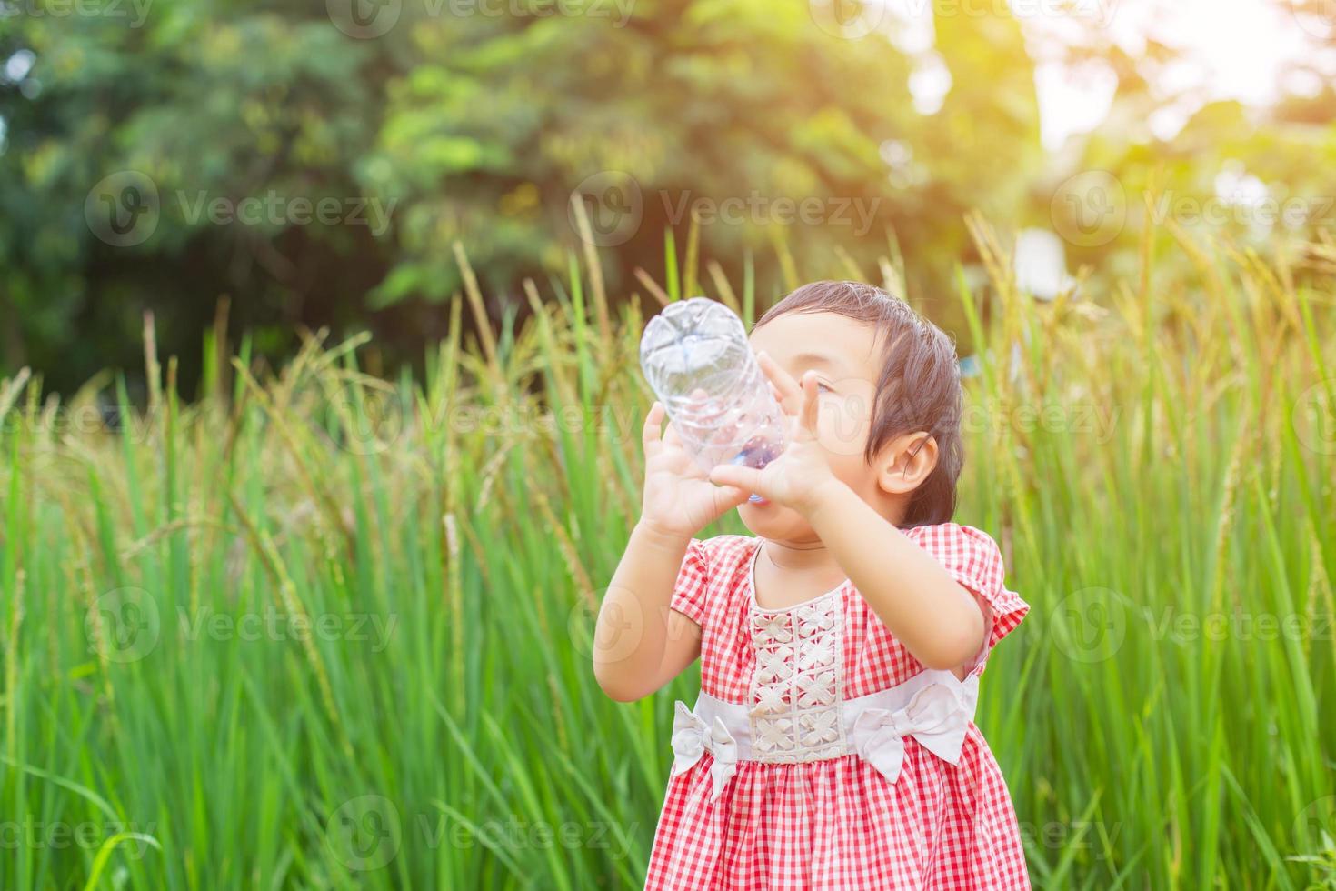jolie petite fille qui boit de l'eau photo