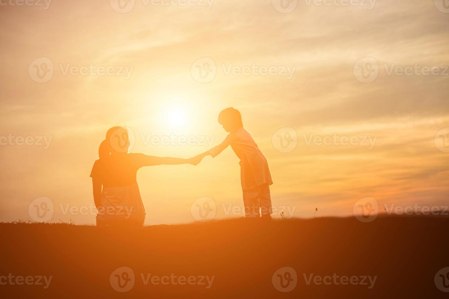 mère a encouragé son fils à l'extérieur au coucher du soleil, concept de silhouette photo